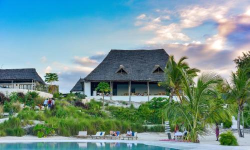 um resort com uma piscina e uma casa em Zanbluu Beach Hotel em Kiwengwa