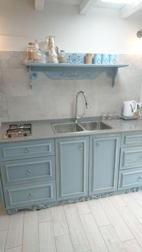 a kitchen with blue cabinets and a sink at Galit's Zimmer in Sha‘alvim