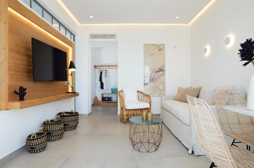 a living room with a white couch and a tv at Phos The Boutique in Akrotiri