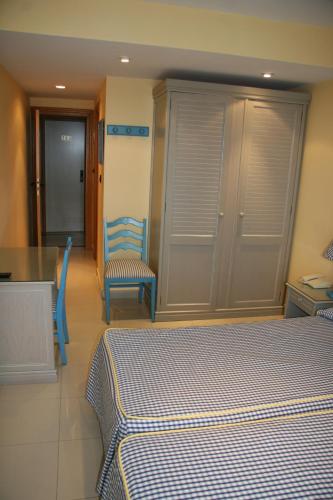 a bedroom with a bed and a table and chairs at Hotel Pineda Playa in Noja