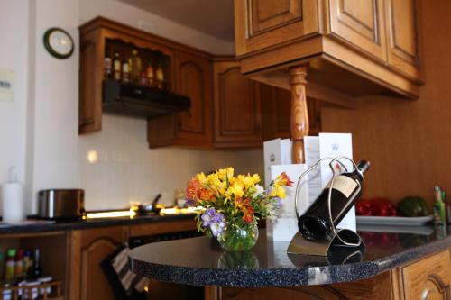 a kitchen with a counter with a vase of flowers at Royal Sun Resort in Acantilado de los Gigantes