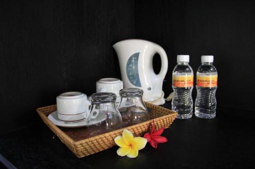 a tray with bottles of water and flowers on a table at Stana Puri Gopa Hotel in Sanur