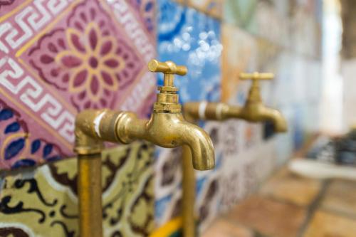 two gold faucets in a bathroom with a wall at Fattoria Capobianco in Montefiascone