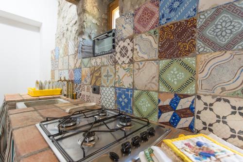 a stove top in a kitchen with a tiled wall at Fattoria Capobianco in Montefiascone