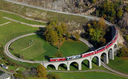 a train on a bridge over a river at Hotel La Romantica in Le Prese, Poschiavo