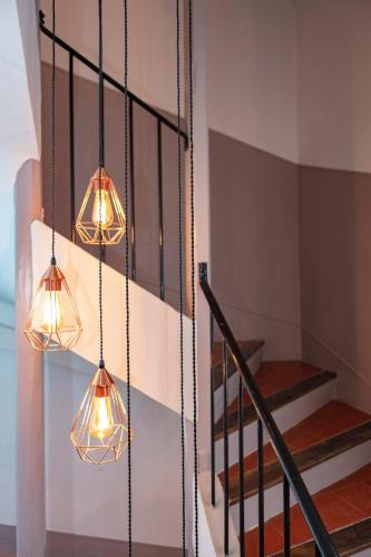 two lights hanging from a wall next to a staircase at Relais Des Alpes in Guillaumes
