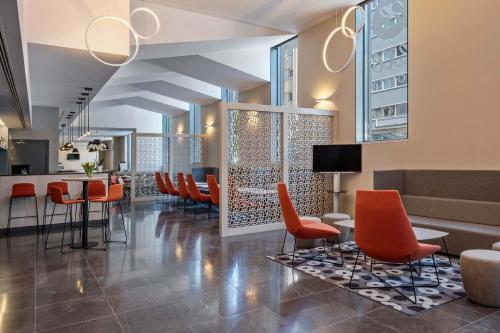 a lobby with orange chairs and a bar at EXE Liberdade in Lisbon