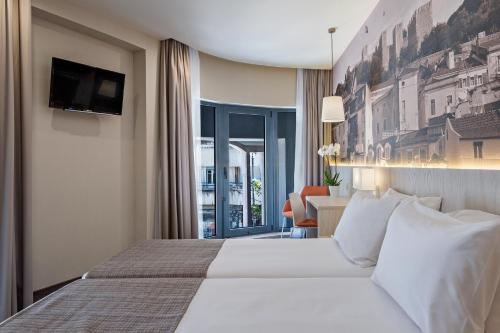 a hotel room with a bed and a table with a chair at EXE Liberdade in Lisbon