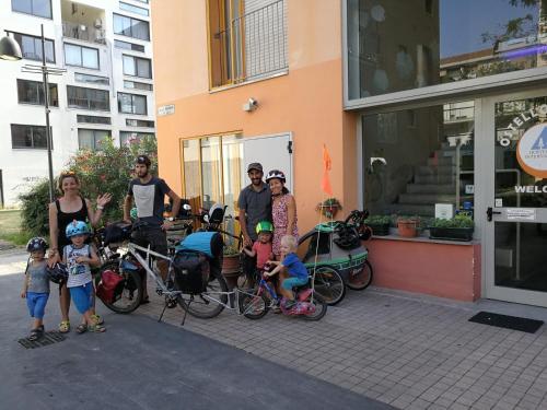 un groupe de personnes debout devant un immeuble avec des vélos dans l'établissement Ostello Torino, à Turin