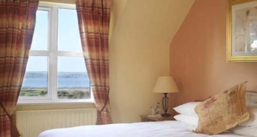 ein Schlafzimmer mit einem Bett und einem Fenster in der Unterkunft Keanes of Curraheen, Bar, Restaurant & Accommodation in Tralee