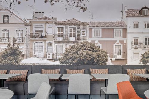 a row of tables and chairs on a balcony with buildings at EXE Liberdade in Lisbon