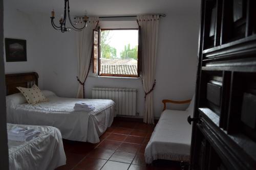 a small room with two beds and a window at Amanecer en Campos in Población de Campos