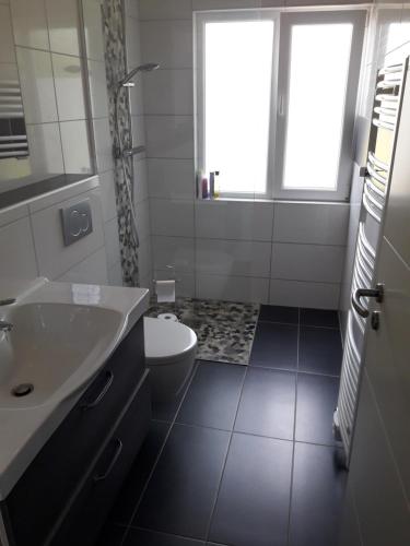 La salle de bains est pourvue d'un lavabo, de toilettes et d'une fenêtre. dans l'établissement Lieblingsmensch Oberhausen mit Terrasse, à Oberhausen