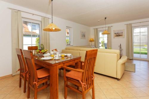a dining room and living room with a table and chairs at Ahornweg 7a in Ostseebad Karlshagen