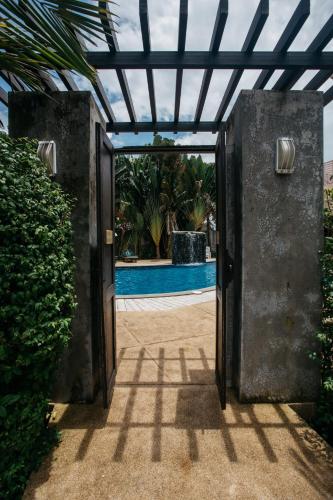 an open door leading to a pool with plants at Diamond Park Inn Chiangrai & Resort in Chiang Rai