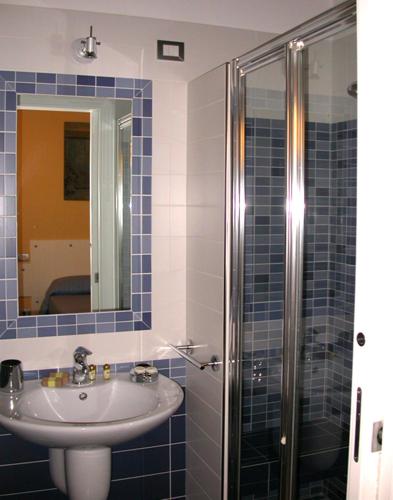 a blue tiled bathroom with a sink and a shower at Bed & Breakfast Palazzo Ducale in Andria