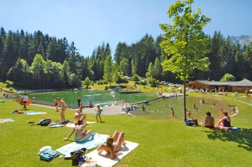 a group of people sitting on the grass at a park at Pension Haus Rohrmoser in Annaberg im Lammertal