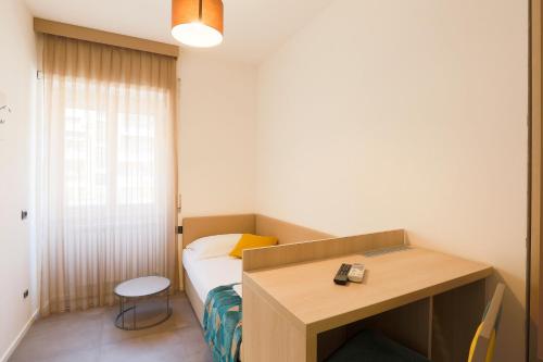 ローマにあるDaVinci Relaisのベッドとデスクが備わる小さな客室です。