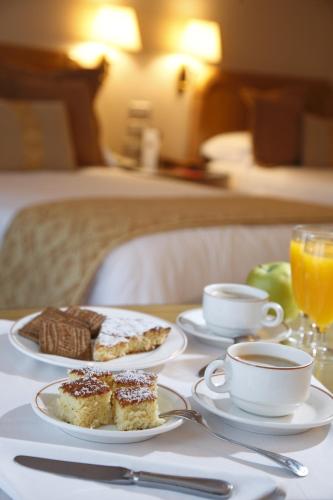 a table with two plates of food and a cup of coffee at Gran Hotel Los Abetos in Santiago de Compostela