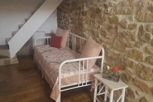 1 dormitorio con cama y pared de piedra en El Encanto de Mora, en Mora de Rubielos