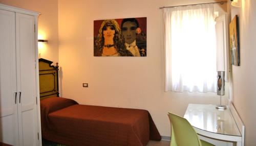 Schlafzimmer mit einem Bett, einem Tisch und einem Fenster in der Unterkunft Bed & Breakfast Palazzo Ducale in Andria