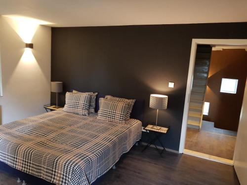 a bedroom with a bed and a black wall at Forester in Malmedy