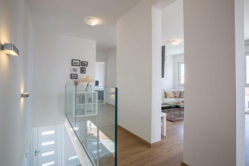 un corridoio bianco con porta a vetri che conduce al soggiorno di Villa Blanka Bol save 15 percent on Split-villas com a Bol
