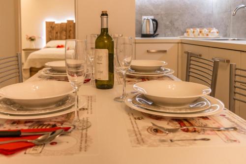 a table with plates and glasses and a bottle of wine at BRAGORA 3524 BETWEEN SAN MARCO AND BIENNALE in Venice