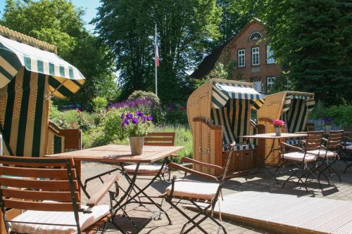 a patio with chairs and a table and a table and chairs at Landhaus Töpferhof bei Travemünde in Travemünde