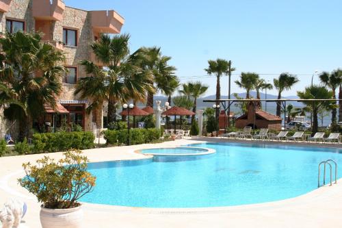 una piscina en un complejo con palmeras en Panorama Plaza, en Koycegiz