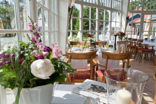 a restaurant with tables and chairs with flowers on them at Landhaus Töpferhof bei Travemünde in Travemünde