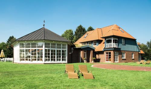 a building with two benches in front of it at Landhaus Töpferhof bei Travemünde in Travemünde