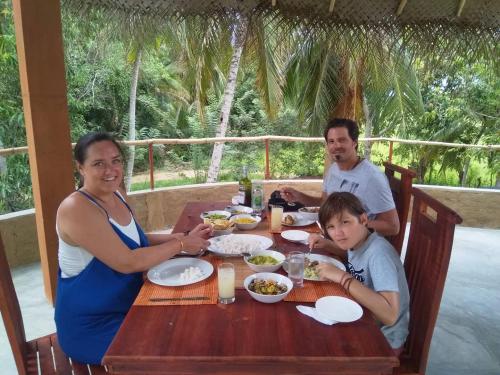 a family sitting at a table eating food at Rice Rice Villas in Tissamaharama