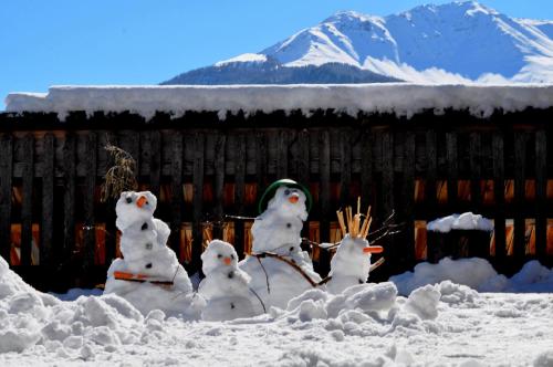 a group of snowmen in the snow in front of a house at Panorama Chalet Heimatliebe in Ladis