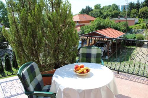 a table with a bowl of fruit on it at Erika Apartmanházak in Hévíz