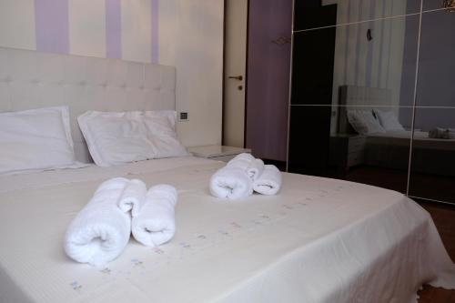 tres toallas están sentadas en una cama blanca en Borgo a Lago, en Sulzano