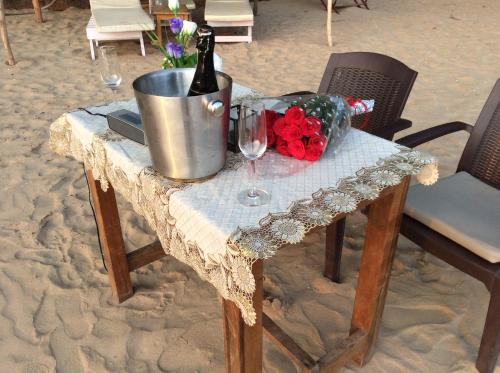 a table with a bottle of wine and glasses on it at Cola Beach Exclusive Resort in Cola