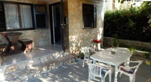 a patio with a table and chairs and a fire place at Shell in Rogoznica