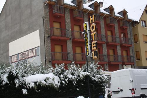 a large building with a hotel sign in the snow at Hotel Vall d´Aneu in Esterri d'Àneu