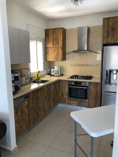 a kitchen with wooden cabinets and a stove top oven at View House in Eilat