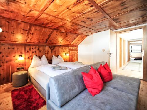 リート・イム・オーバーインタールにあるAparthaus Teresaのベッドルーム1室(ベッド1台、ソファ、赤い枕付)