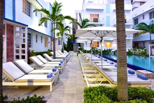 a row of lounge chairs by a pool at a hotel at Pestana South Beach Hotel in Miami Beach
