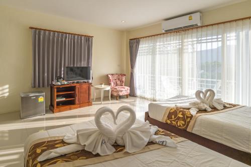 a hotel room with two beds with towels at Alisa Krabi Hotel-SHA Plus in Krabi town