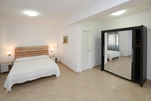 a bedroom with a large bed and a mirror at villa aurora in Giardini Naxos