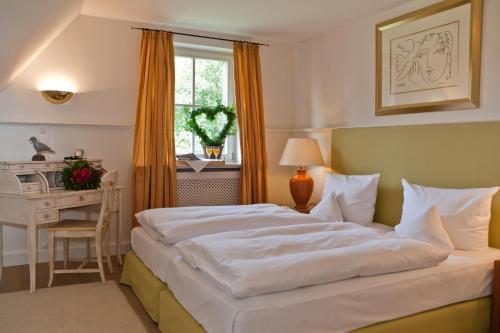 a bedroom with a bed and a desk and a window at Landhaus Töpferhof bei Travemünde in Travemünde