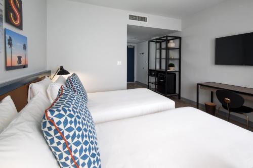 a hotel room with two beds and a television at Generator Miami in Miami Beach