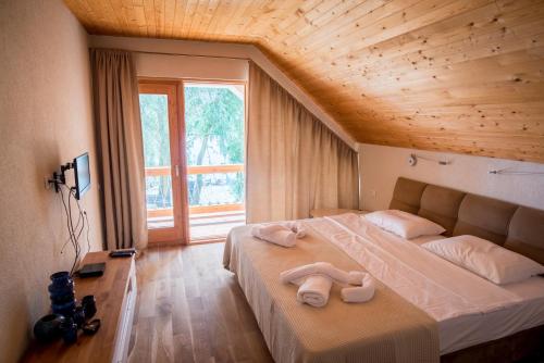 a bedroom with a large bed with towels on it at Living In Delta - Casa de vacanta in Crisan