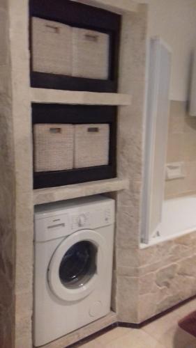 eine Waschmaschine und einen Trockner im Bad mit einer Wand in der Unterkunft Villa Victoria in Gradac