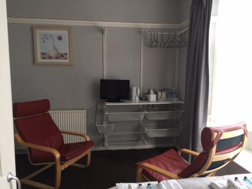 a living room with two chairs and a television at Tudor Lodge in Scunthorpe