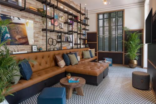 a living room with a brown couch and a brick wall at Generator Miami in Miami Beach